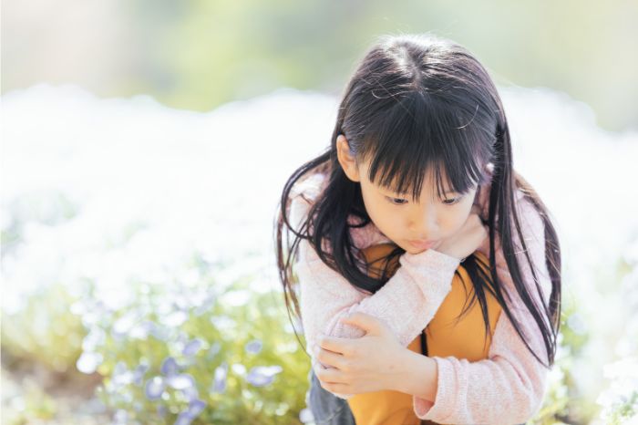 花畑でうつむく女の子の写真